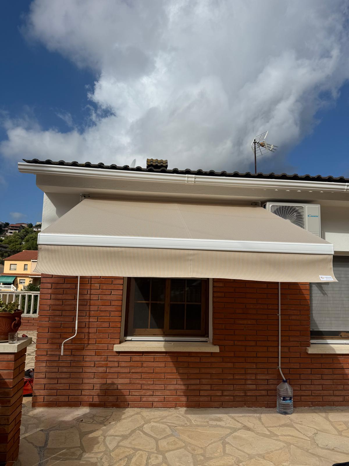Toldo de brazo extensible instalado junto a una piscina